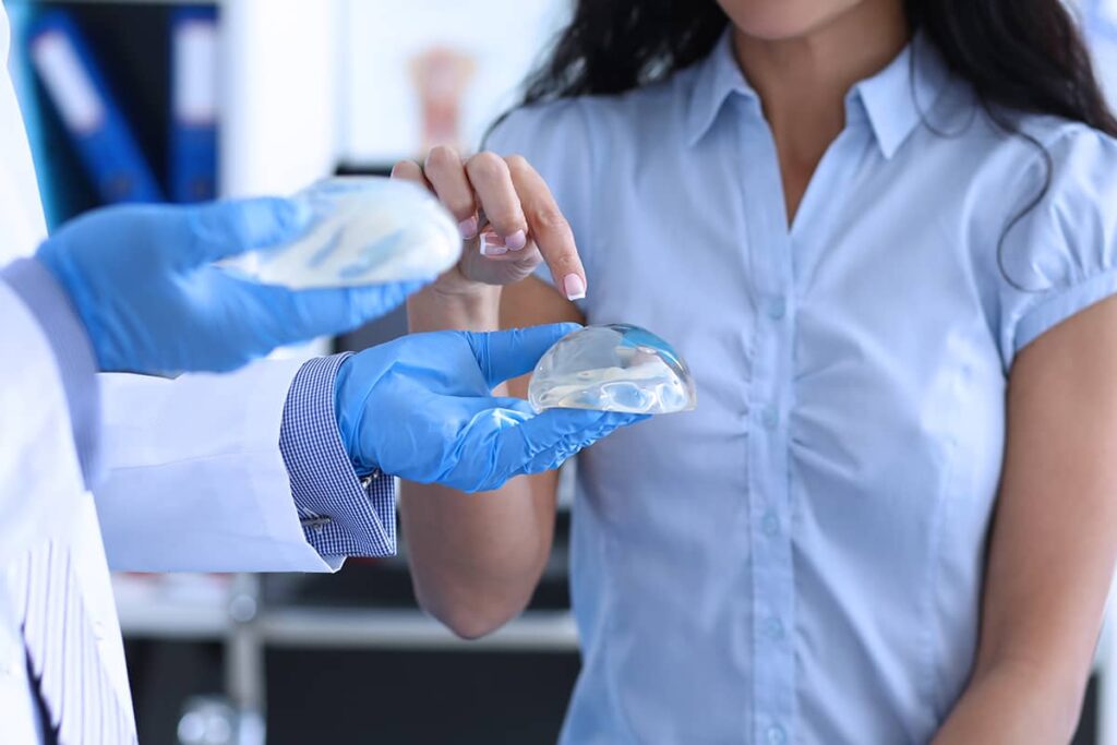 A woman examines breast implants during a consultation.
