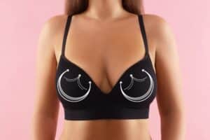 Illustrated comparison of breast lift and implant options on a sports bra.