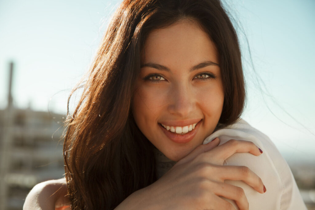 Close-up of a content woman smiling, exemplifying potential results of varied lip lift techniques.