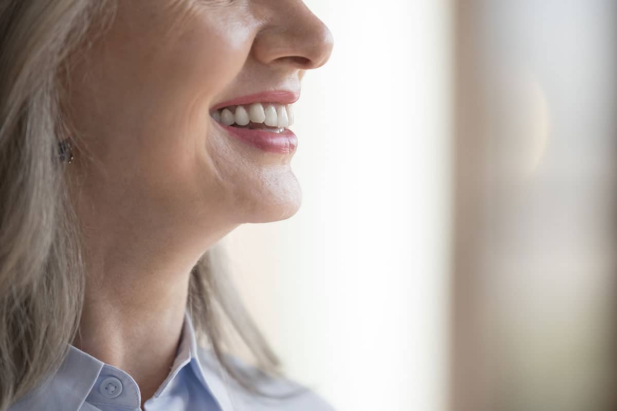 Close up to the lower face of a mature patient who had a chin implant procedure and is now recovering.