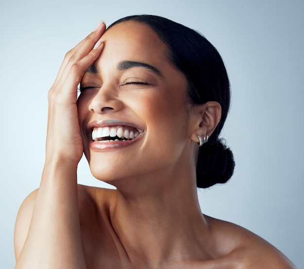 Joyful woman touching her forehead represents one-month post-brow lift improvement.