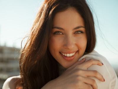 Close-up of a content woman smiling, exemplifying potential results of varied lip lift techniques.