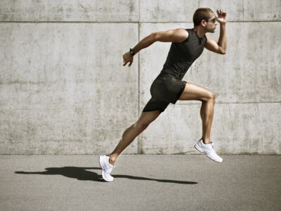Runner in mid-stride showcasing potential toned calves ideal for implants.